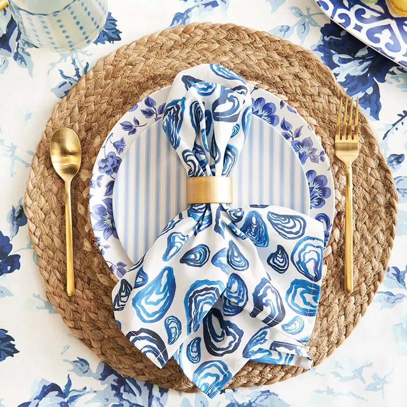 Blue oyster pattern napkin on a blue floral table cloth.