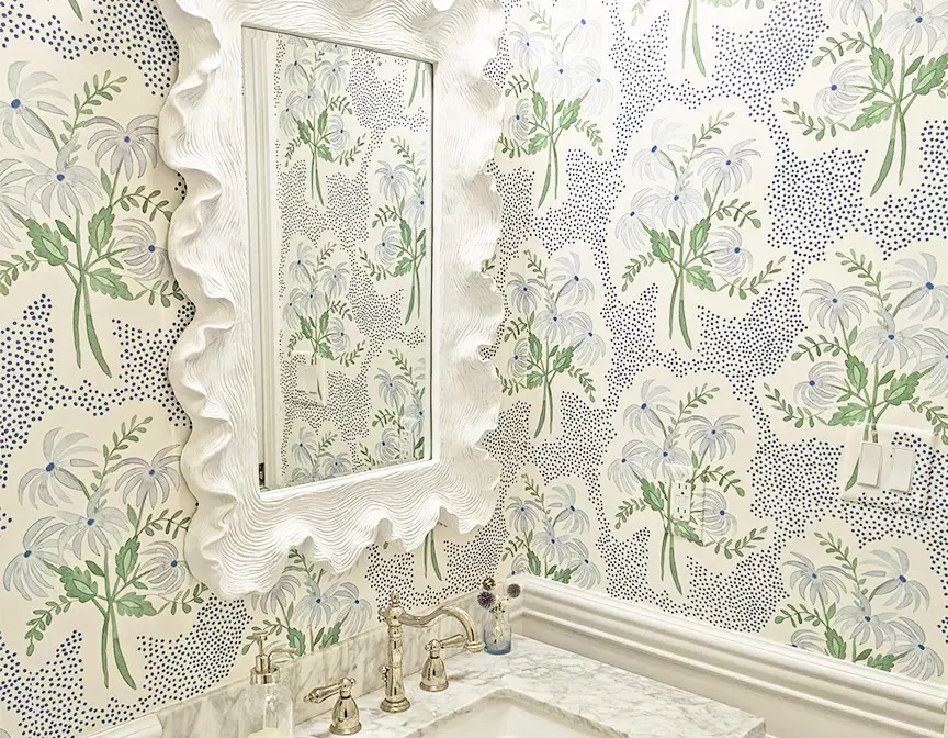 Bathroom wallpapered with light blue floral wallpaper.
