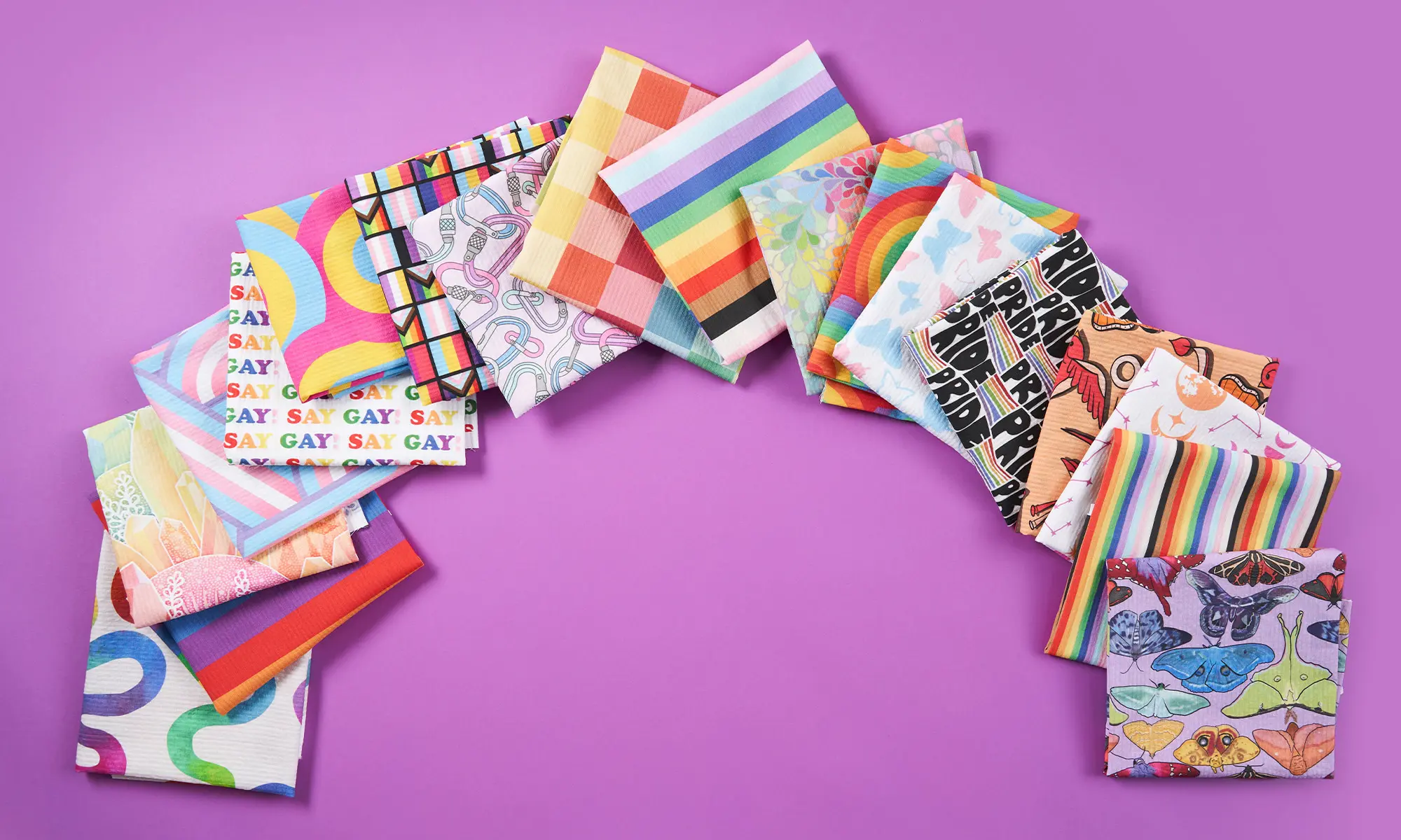 Pride themed designs printed on seersucker fabric arranged in an arch like a rainbow.