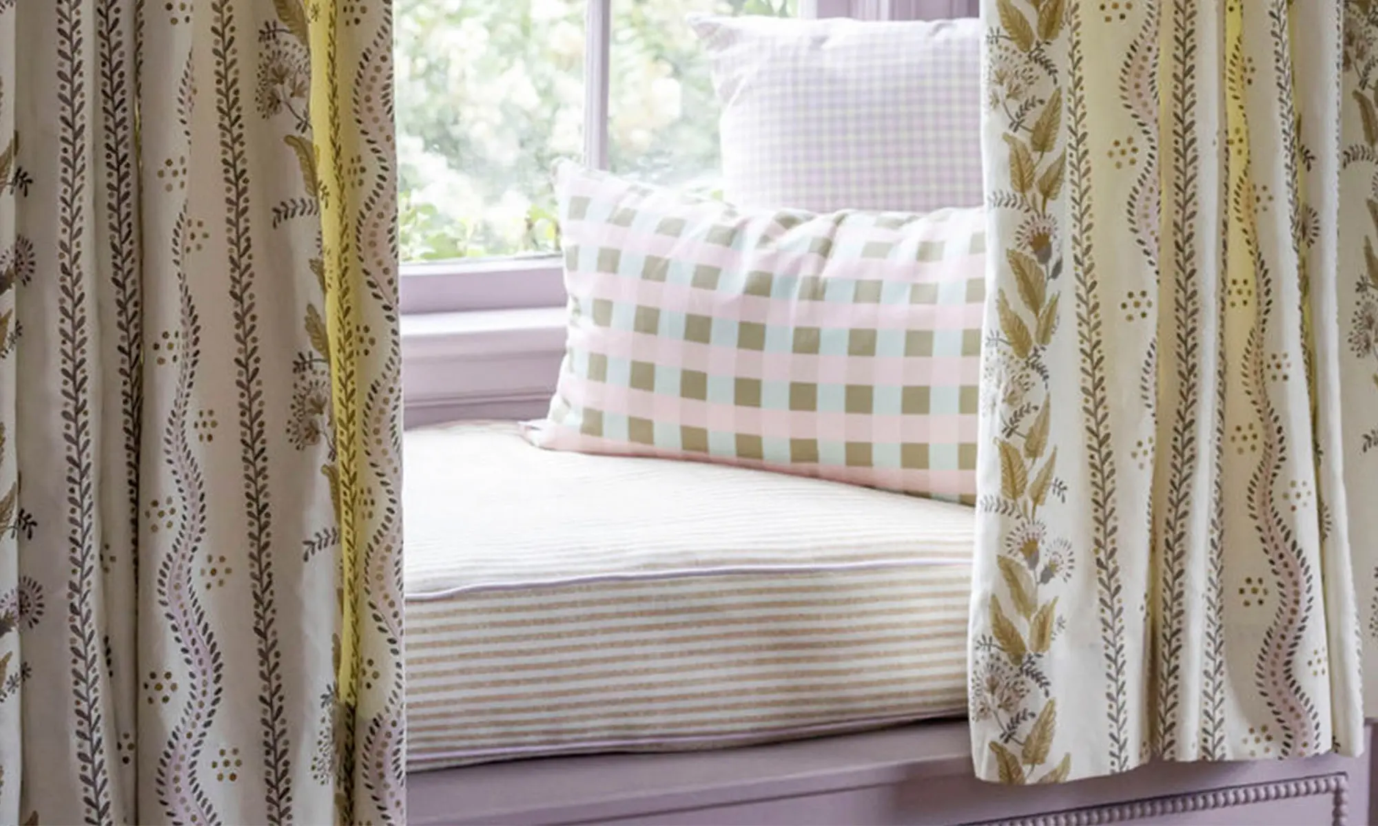 Window seat with pillows and curtains.