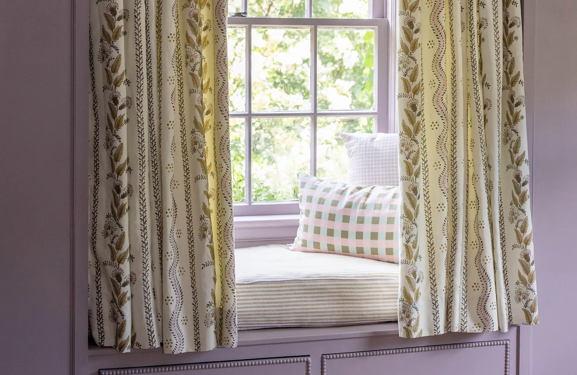 Window seat with curtains, pillows, and cushion