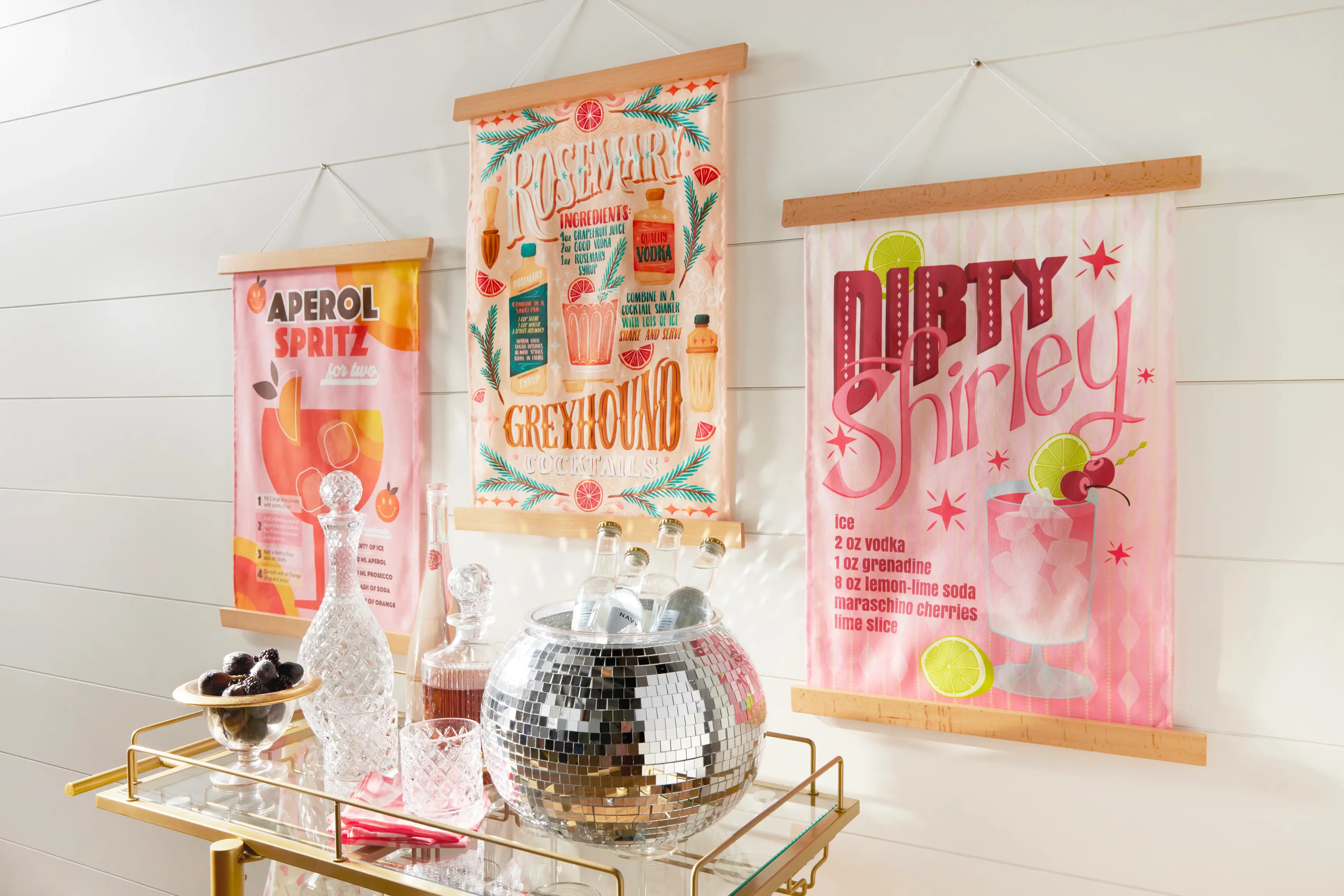 Wall hanging's with drink recipes over a bar cart